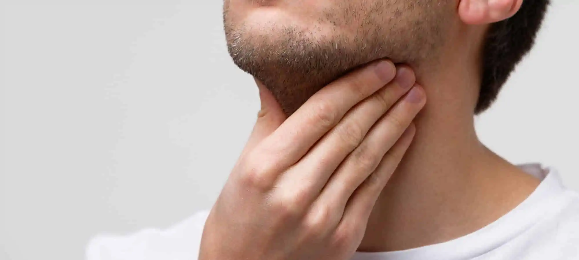 Man holding hand on sore throat