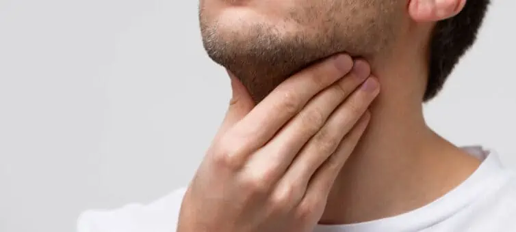 Man holding hand on sore throat