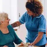 Senior and nurse speaking 
