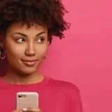 Women looking off to the side with her cell phone in hand