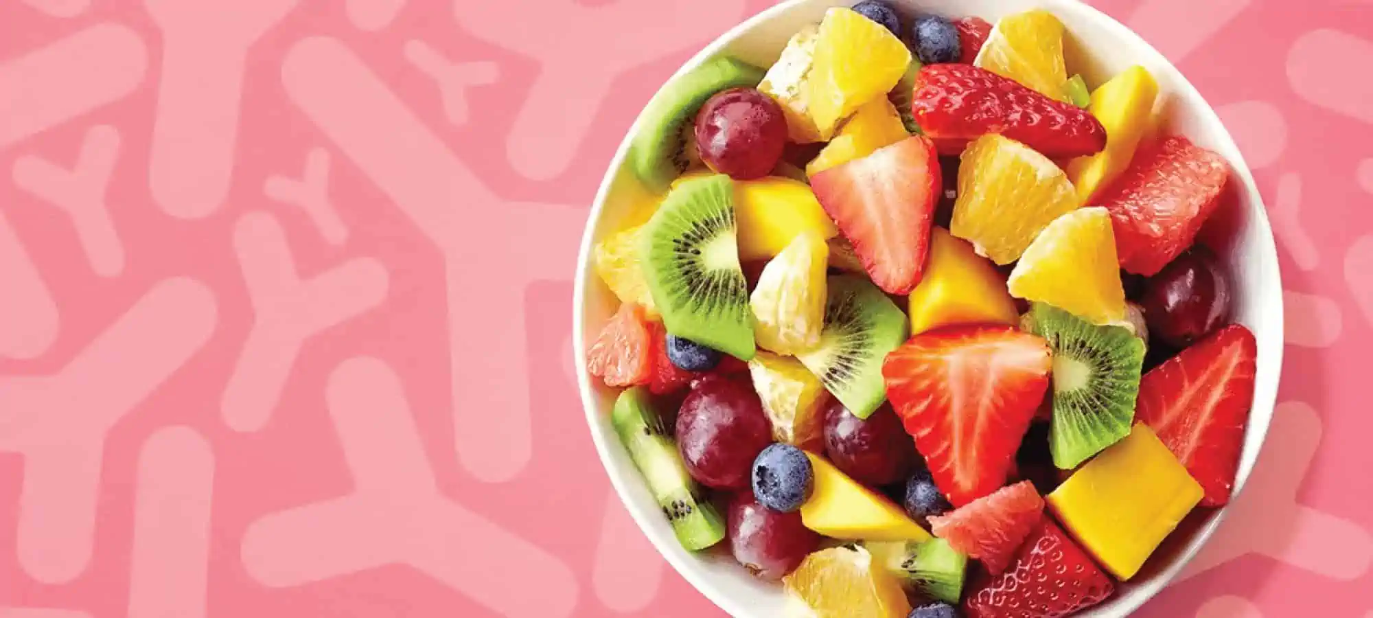 Bowl of fruit with pink microbe background
