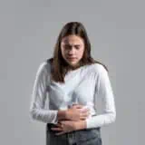 Young woman clutching her stomach in pain