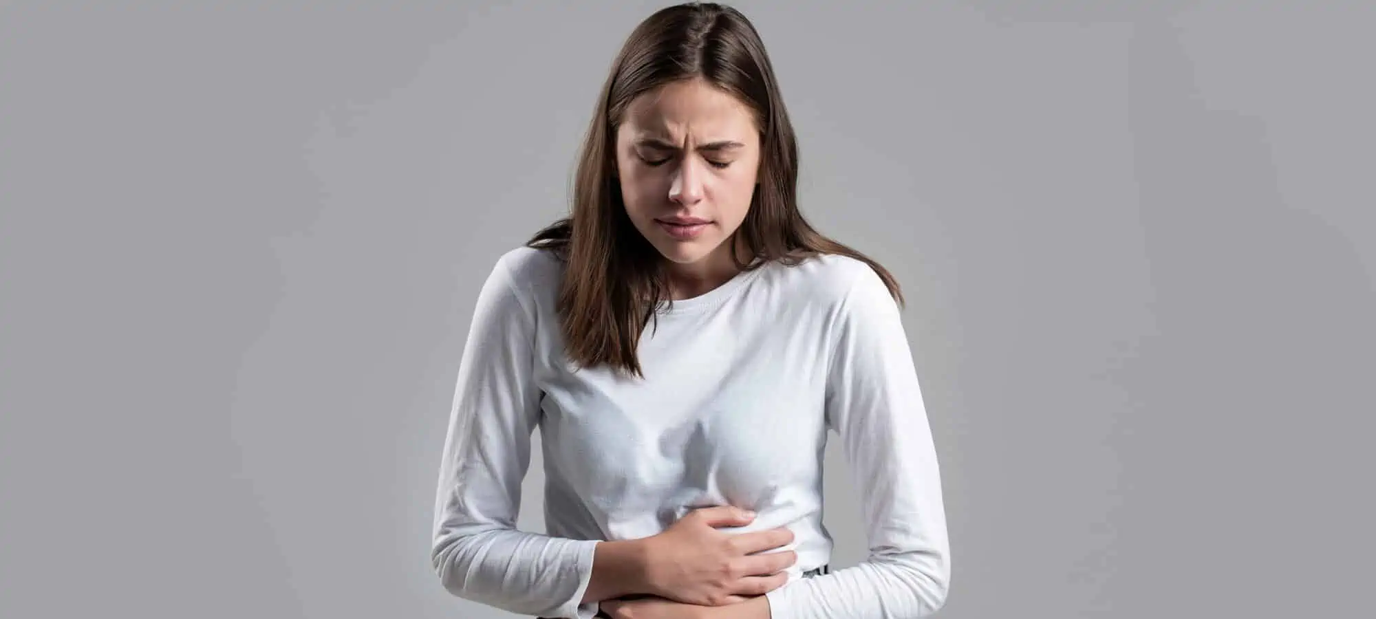 Young woman clutching her stomach in pain