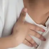 Women holding chest with GERD