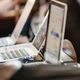 People sitting on a computer listening to a presentation