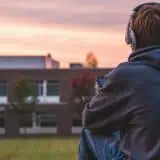 Teenager sitting outside with headphones on