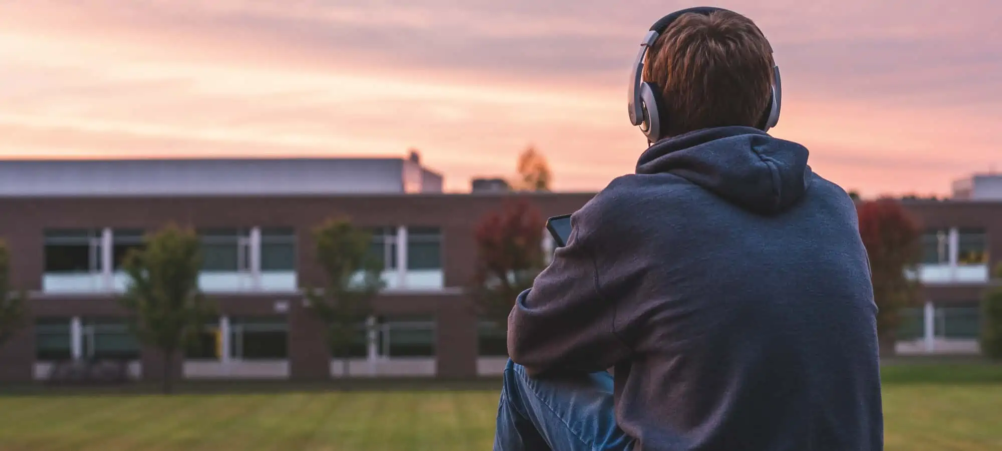 Teenager sitting outside with headphones on