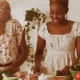 Women laughing and cooking together in a kitchen