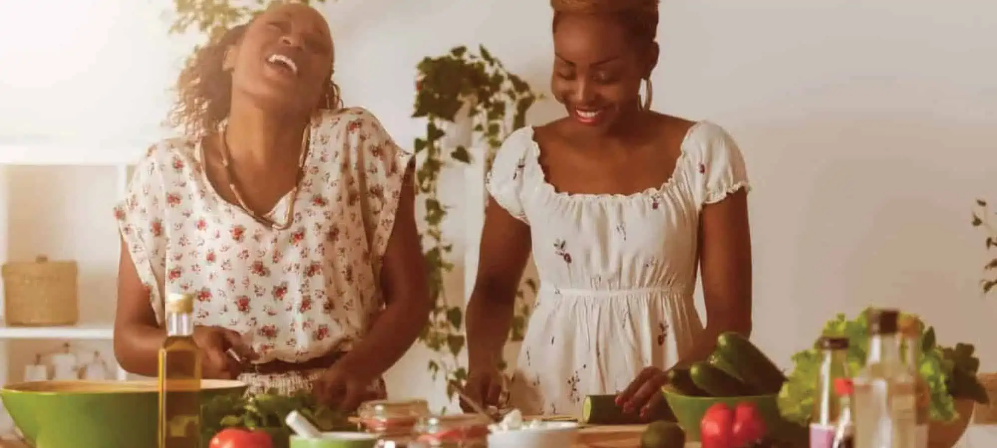 Women laughing and cooking together in a kitchen