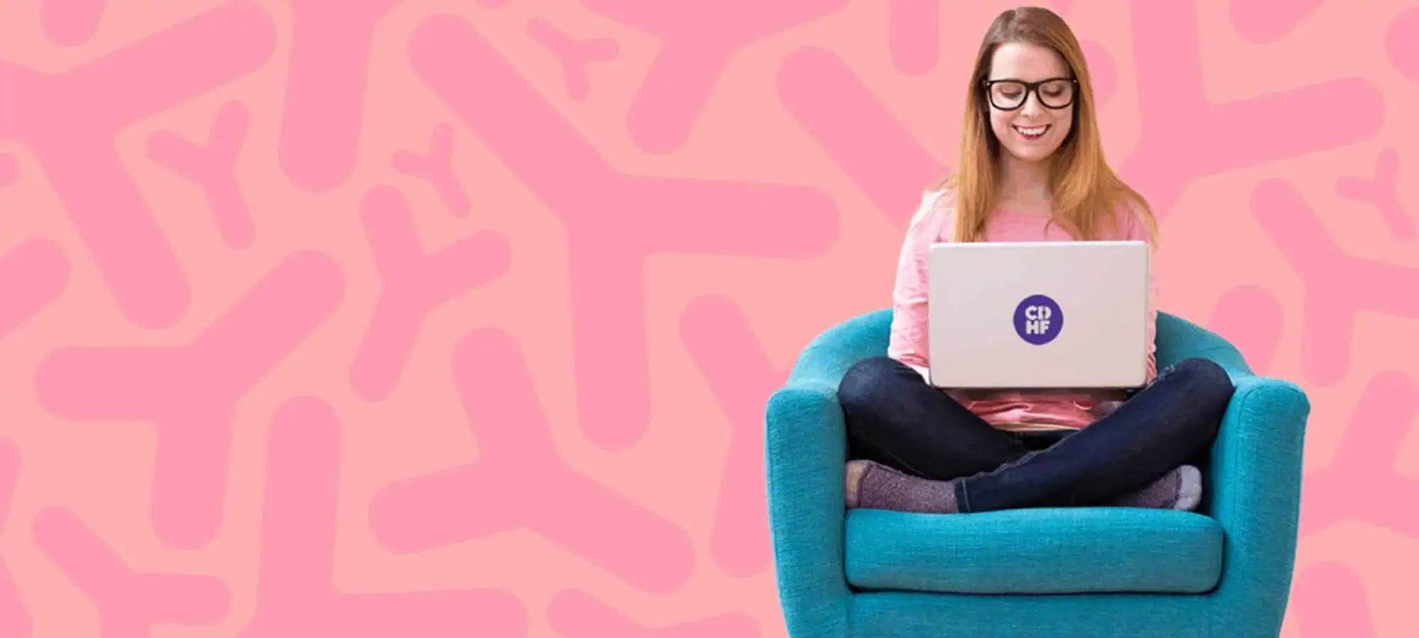 Woman in chair reading her laptop and smiling