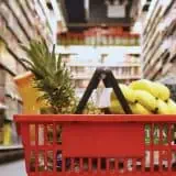Grocery cart filled with groceries on the aisle floor