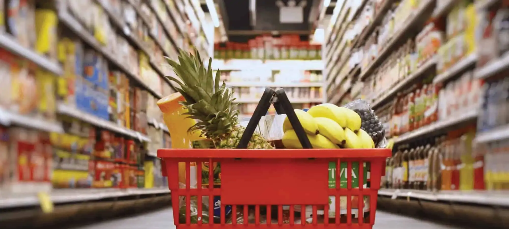 Grocery cart filled with groceries on the aisle floor
