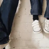 man and child wearing jeans and sneakers with feet dangling