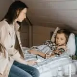 Mom taking care of sick son with gastrointestinal disease in bed