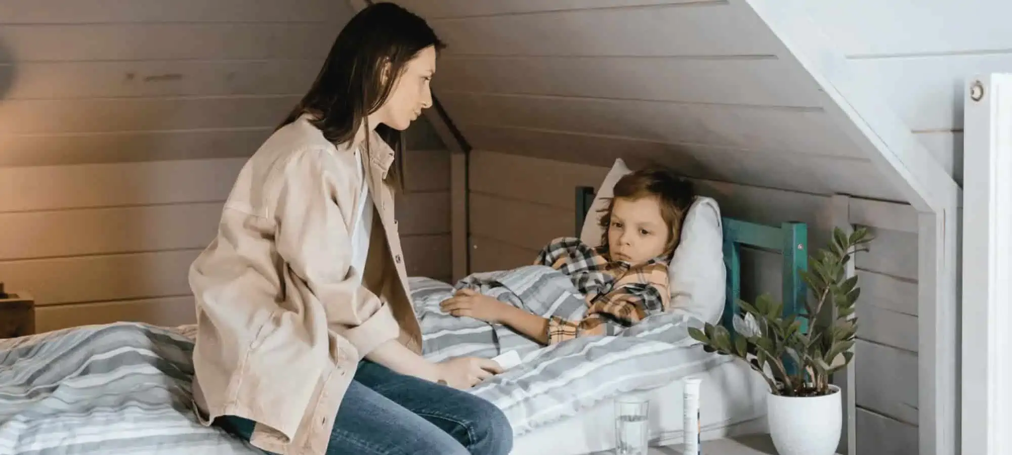Mom taking care of sick son with gastrointestinal disease in bed