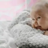 Baby laying down with microbes in the background