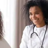 Doctor speaking to teenager in office