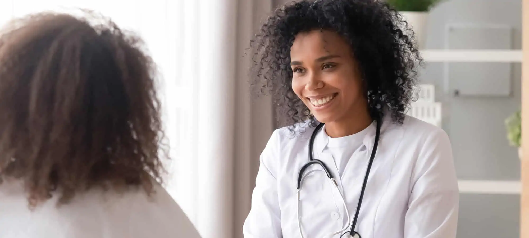 Doctor speaking to teenager in office