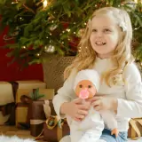 young girl holding baby doll