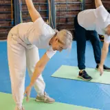 elder man and woman stretching on yoga mats