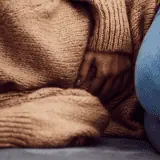 woman laying down with hurt stomach