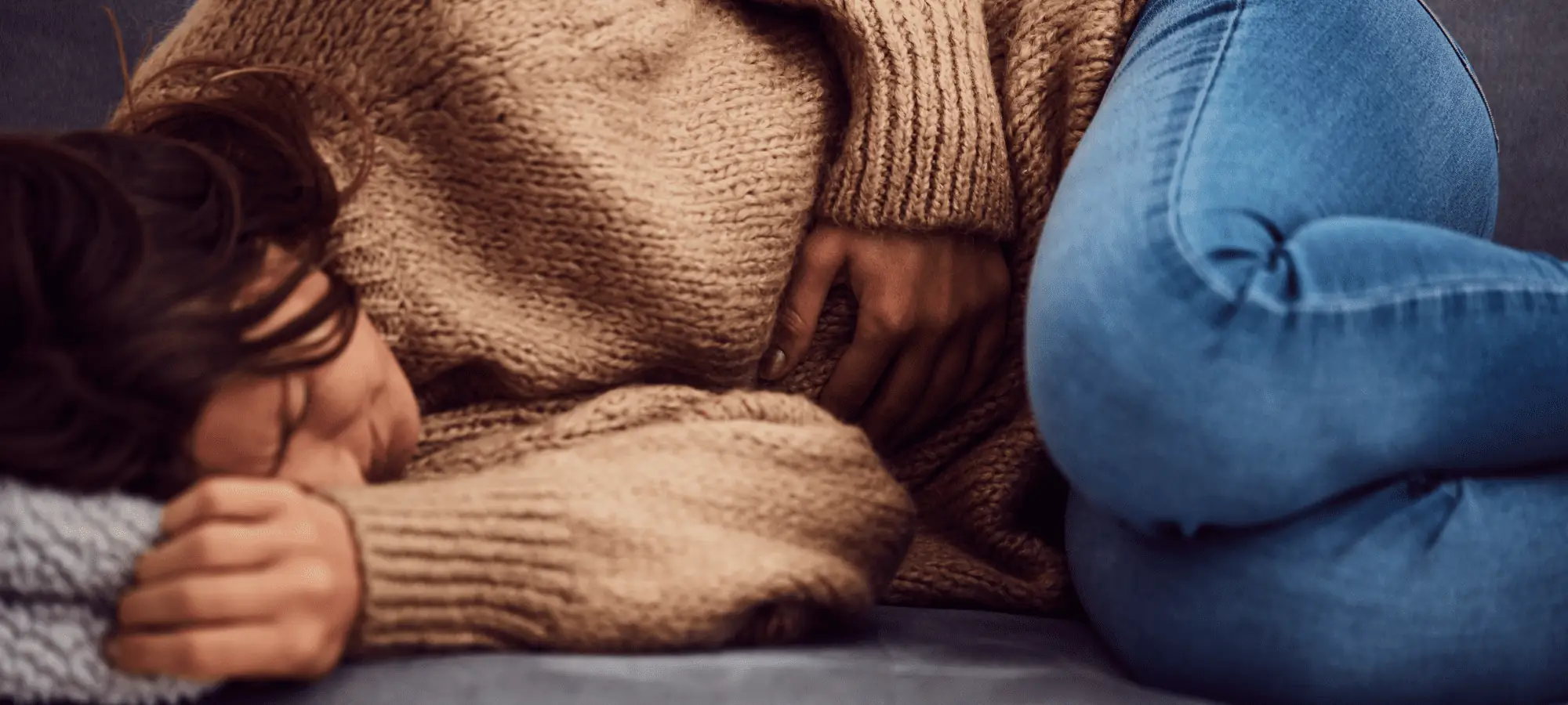 woman laying down with hurt stomach