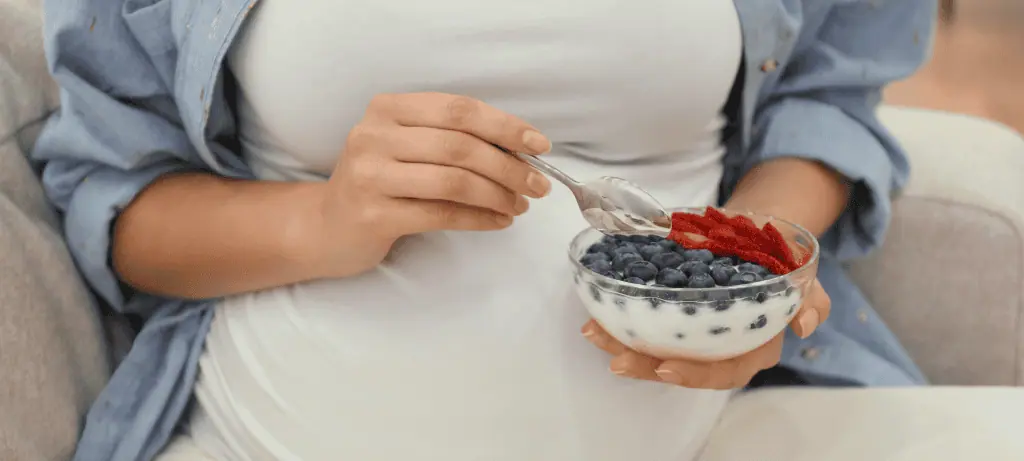 pregnant person eating probiotic yogurt