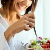 women eating a high fibre salad smiling