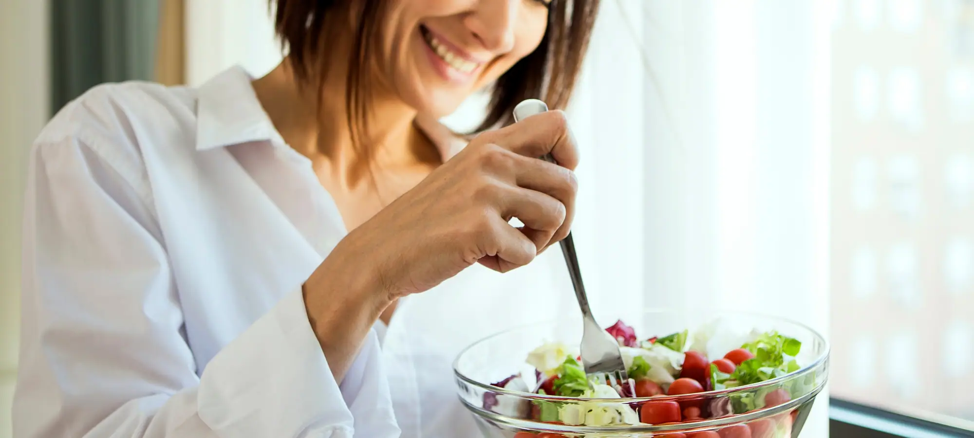 women eating a high fibre salad smiling
