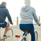 older couple riding on bikes getting exercise